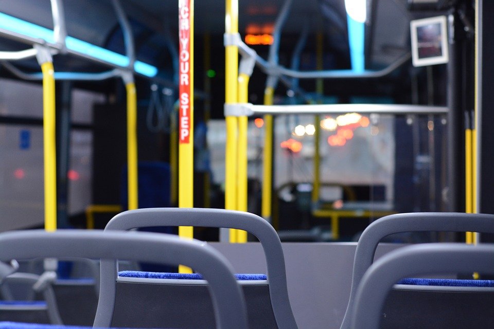 a view of rows of empty bus seats on a public transit bus