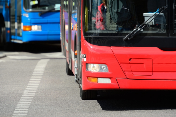 two public transit buses in traffic