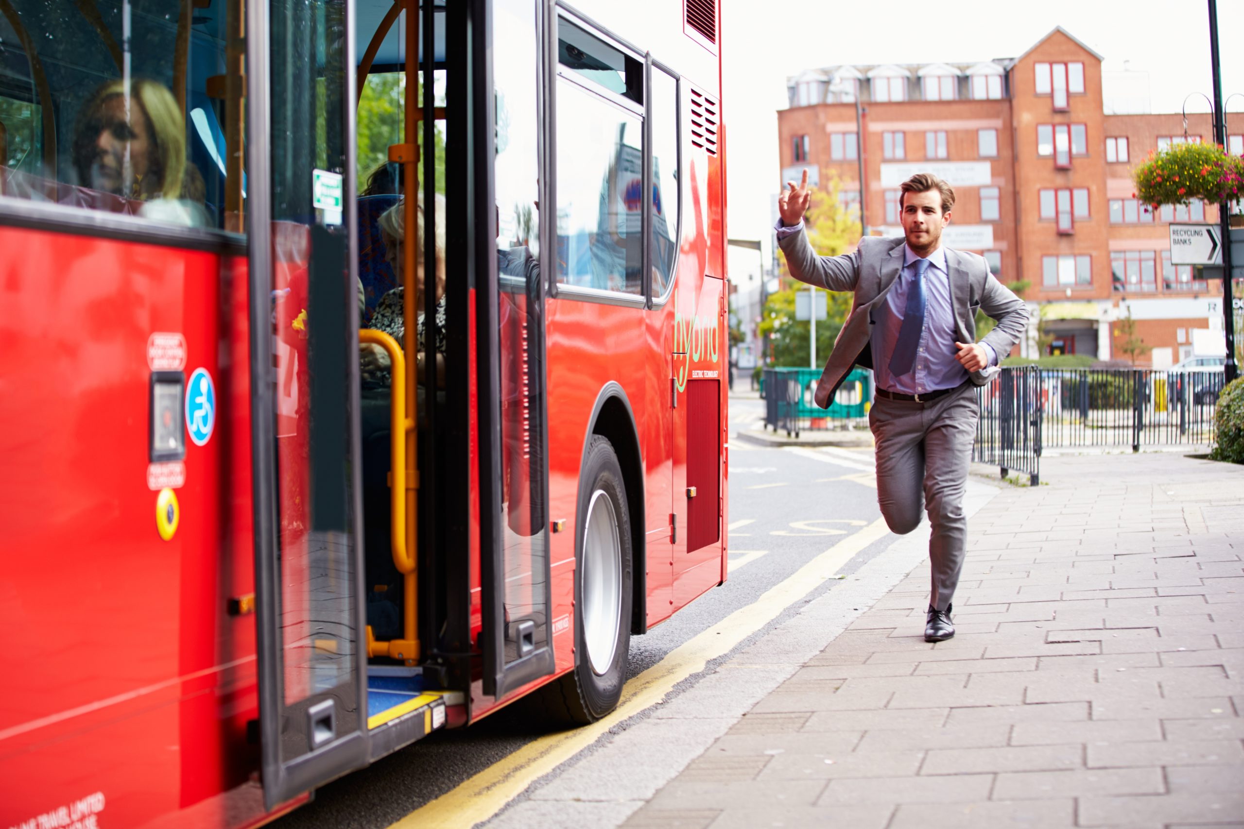 a business man running to catch his bus.
