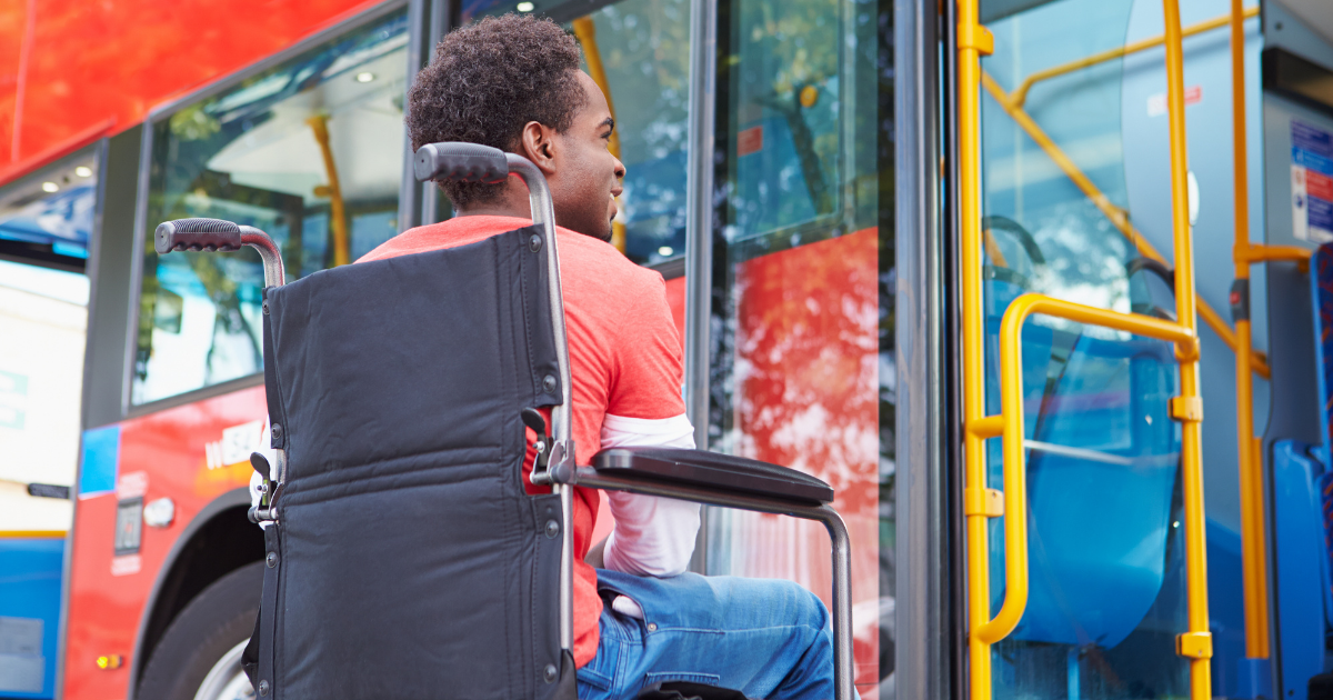 young man in wheelchair boarding a bus