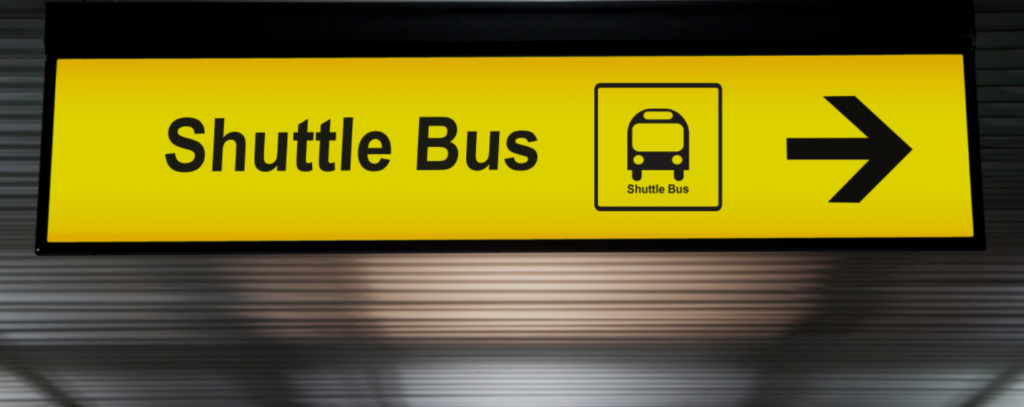 sign pointing to a shuttle bus stop