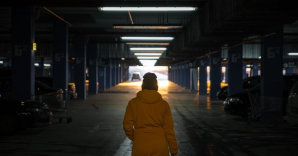 view from behind a woman walking in a dark hospital parking garage