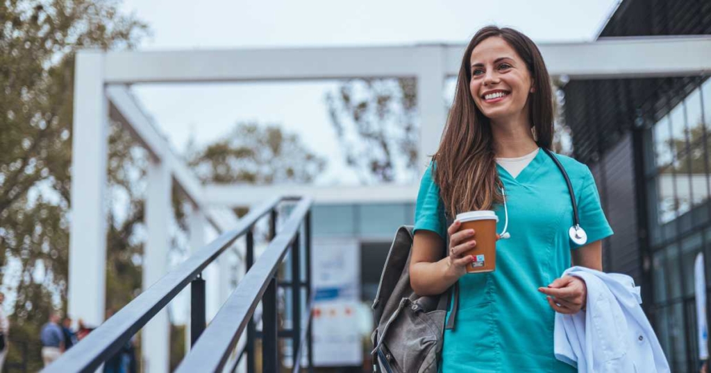 medical worker with coffee cup walking down stairs