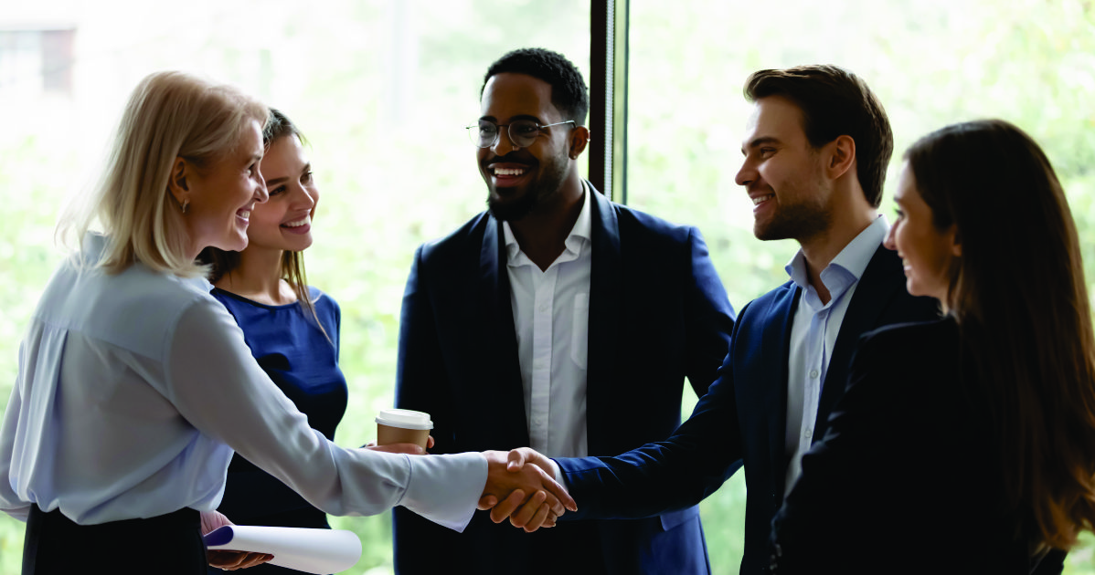 group of business people with a man and a woman shaking hands