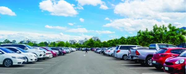 Long view of a parking lot with cars along both sides
